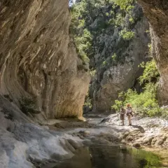 Deux randonneurs explorent les formations rocheuses spectaculaires des concluses de Lussan, un paysage naturel impressionnant.