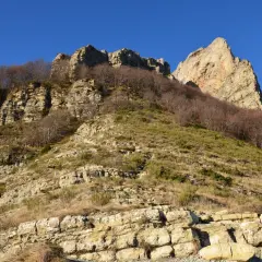 Vue spectaculaire des 3 becs, falaises rocheuses et arbres dénudés sous un ciel bleu intense.