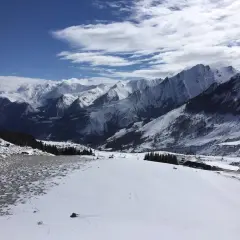 Vue panoramique depuis le col du Soulor, montagnes enneigées sous un ciel bleu et nuageux.