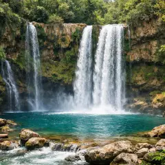 Magnifique cascade saut de la virole, ses eaux turquoise tombent sur des rochers moussus, entourée d'une végétation luxuriante.