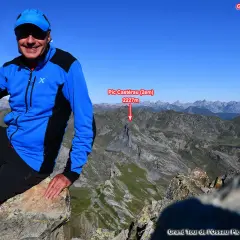 Randonneur souriant au sommet du Pic de Peyreget, point de départ du Grand Tour du Pic du Midi d'Ossau. Paysage montagneux spectaculaire.