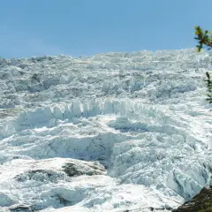 Vaste étendue de glace craquelée et texturée du glacier des Bossons sous un ciel bleu clair.