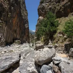 Sentier rocailleux dans les gorges de Franchard, entre falaises abruptes et végétation méditerranéenne. Un cairn marque le chemin.