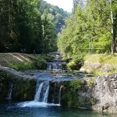 La cascade du Morel dévale une série de bassins aménagés, entourée d'une végétation luxuriante et de promeneurs.