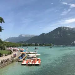 Vue animée de la plage de l'Impérial avec des pédalos et des montagnes en arrière-plan.