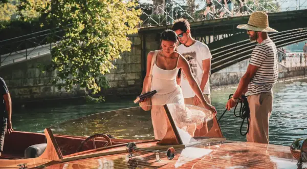 Couple profitant d'une activité à Annecy, embarquant sur un bateau en bois.