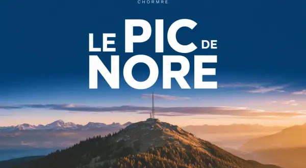 Le pic de Nore, sommet majestueux sous un ciel bleu, dominé par une antenne. Paysage montagneux au coucher du soleil.