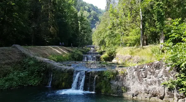 La cascade du Morel dévale une série de bassins aménagés, entourée d'une végétation luxuriante et de promeneurs.