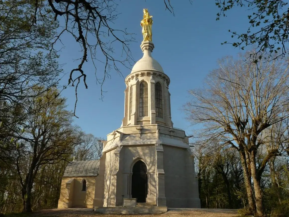 Chapelle de Notre-Dame d'Afrique à Dijon, dominée par une statue dorée. Un lieu de quiétude au cœur de la nature.