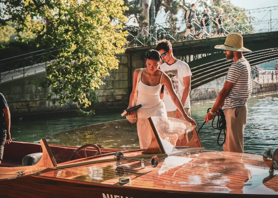 Couple profitant d'une activité à Annecy, embarquant sur un bateau en bois.