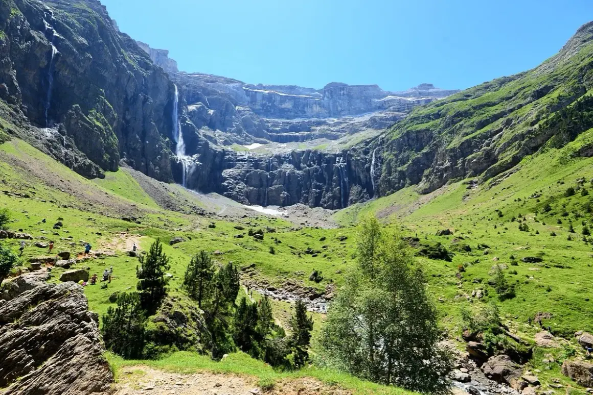 Le cirque de Gavarnie, un amphithéâtre naturel de montagnes majestueuses, est traversé par de nombreuses cascades tombant en rideaux d'eau sur les parois rocheuses.