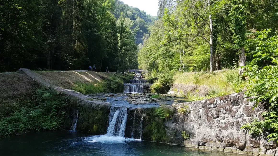 La cascade du Morel dévale une série de bassins aménagés, entourée d'une végétation luxuriante et de promeneurs.