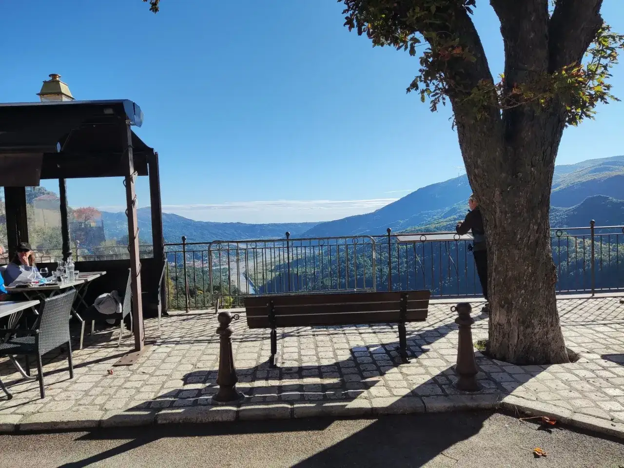 Terrasse avec vue sur la vallée et le lac du Broc. Un banc invite à la contemplation du paysage.