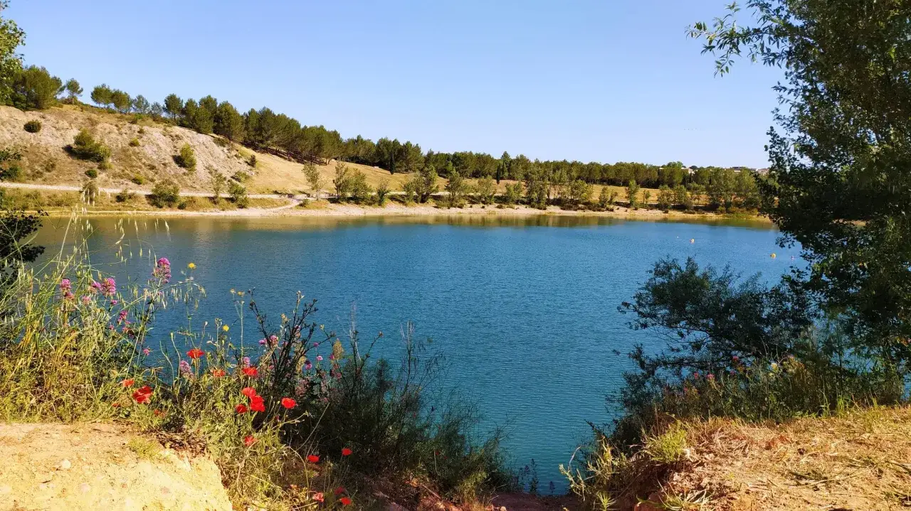 Magnifique lac bleu, bord&eacute; de v&eacute;g&eacute;tation et de collines. Un sentier serpente le long de l'eau, parfait pour un itin&eacute;raire de d&eacute;couverte du lac du Cr&egrave;s.