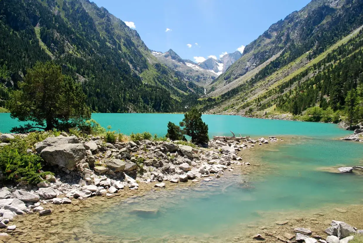 Magnifique lac de Gaube aux eaux turquoise, entouré de montagnes verdoyantes et enneigées. Un paysage de carte postale.