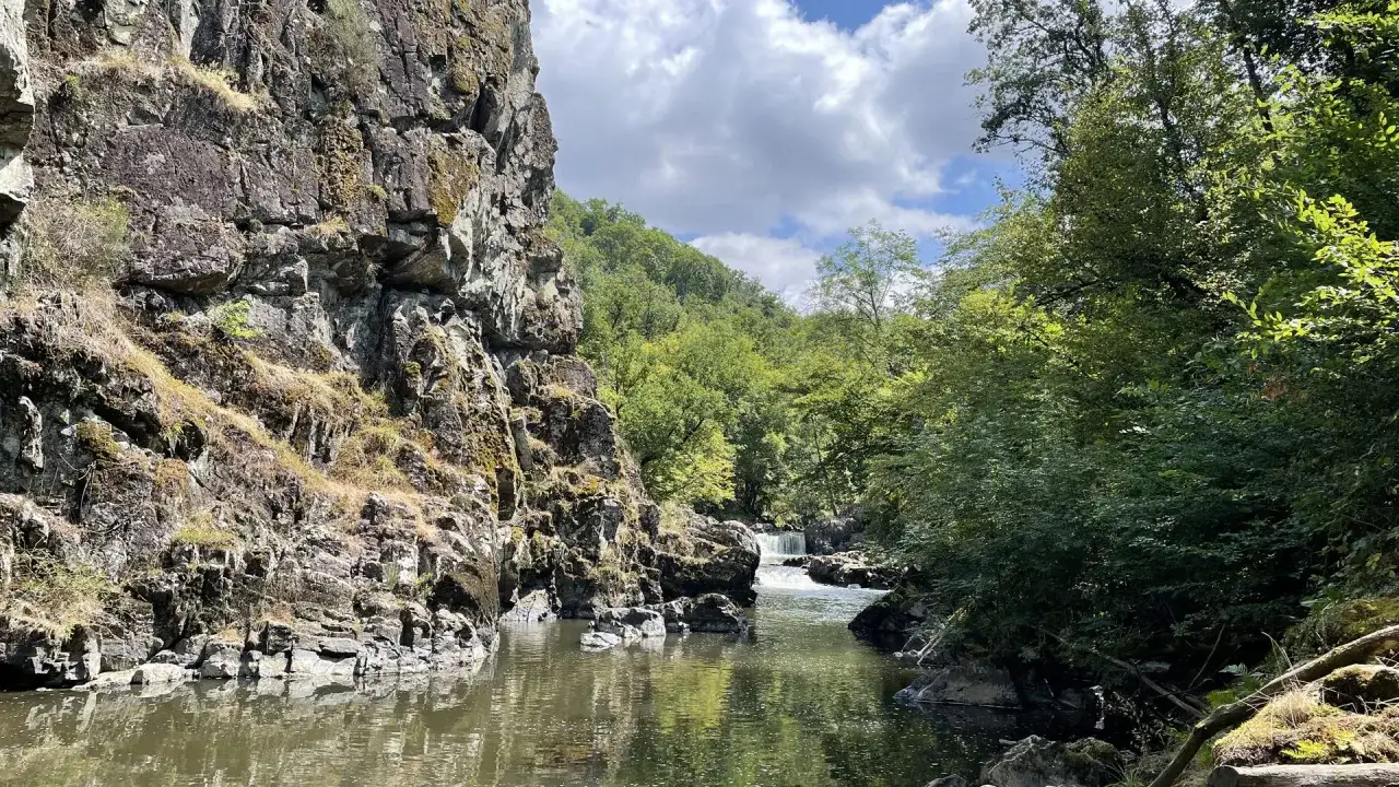 La cascade du Saut du Ruban se d&eacute;voile entre falaises rocheuses et v&eacute;g&eacute;tation luxuriante, un spectacle naturel saisissant.