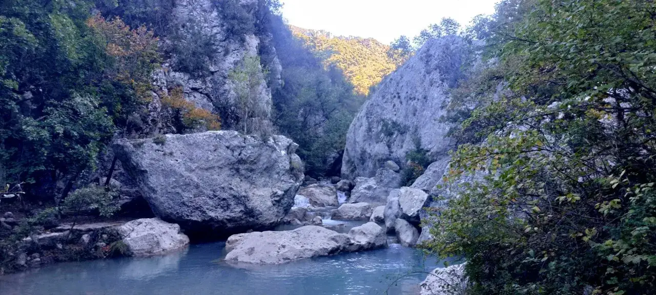 Les gorges de Tr&eacute;vans, un paysage sauvage avec une rivi&egrave;re aux eaux bleues, des rochers imposants et une v&eacute;g&eacute;tation luxuriante.