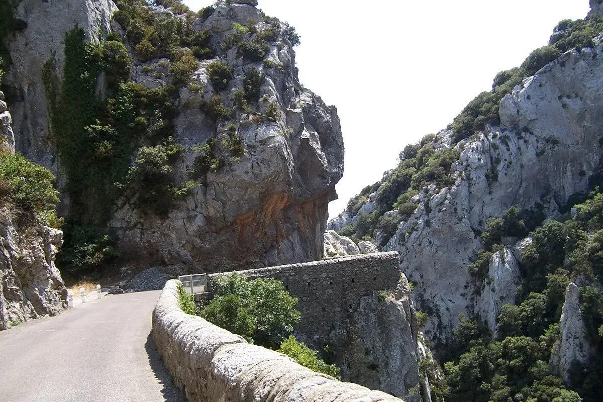 Route sinueuse longeant les falaises abruptes des gorges de Galamus, offrant un panorama spectaculaire.