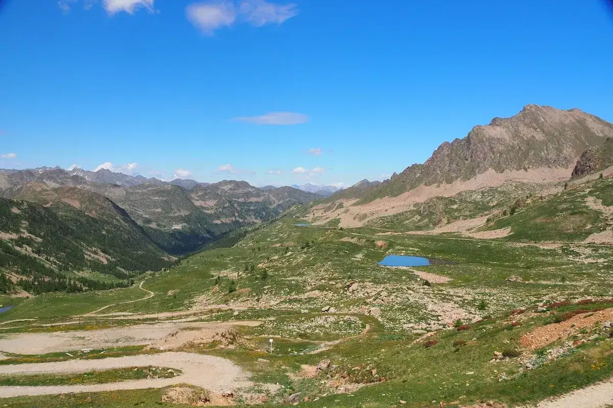 Vue panoramique du col de la Lombarde, avec ses montagnes majestueuses, ses lacs bleus et ses sentiers sinueux.