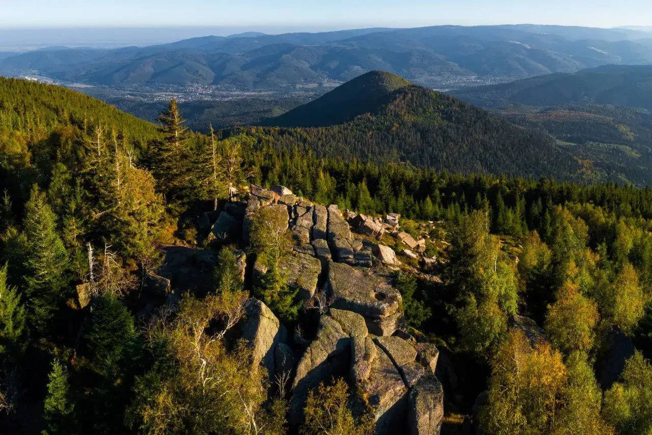 Vue panoramique depuis le rocher de Mutzig, avec des forêts denses et des montagnes ondulantes à l'horizon.