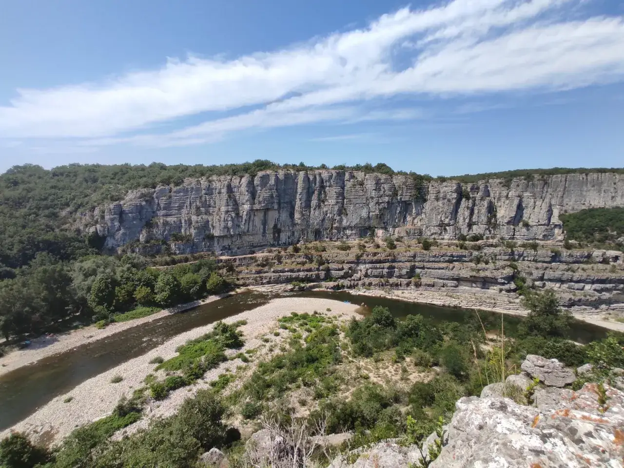 Le cirque de gens, un paysage spectaculaire de falaises calcaires sculpt&eacute;es par la rivi&egrave;re Ard&egrave;che, sous un ciel bleu parsem&eacute; de nuages.