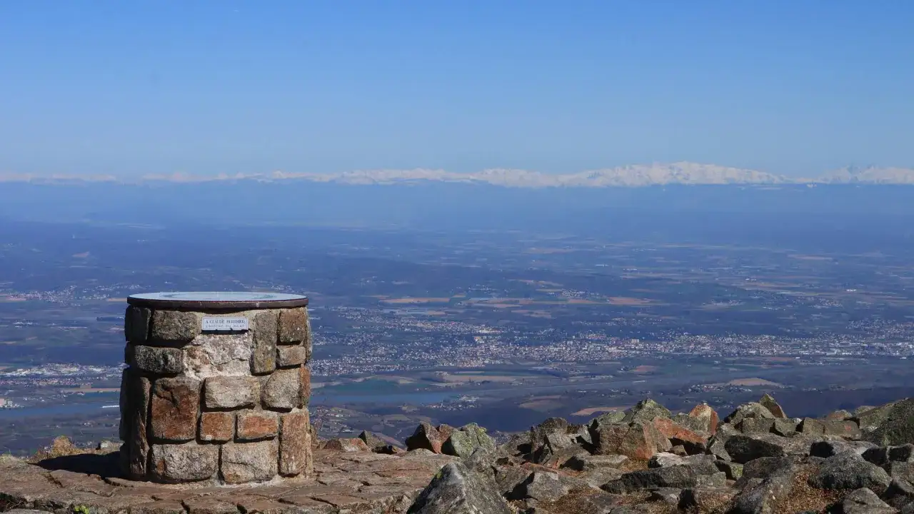 Monument en pierre au col de l'Oeillon, offrant une vue panoramique sur la vall&eacute;e et les montagnes enneig&eacute;es au loin.