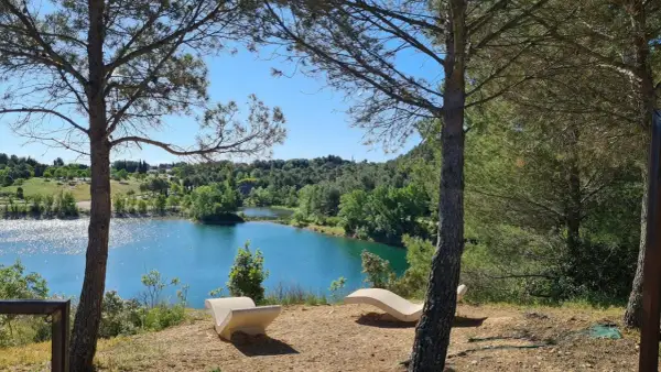 Deux chaises longues en pierre invitent à la contemplation du lac du Crès. L'itinéraire de ce lieu paisible est un appel à la nature.