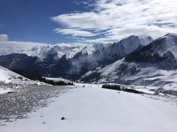 Vue panoramique depuis le col du Soulor, montagnes enneigées sous un ciel bleu et nuageux.