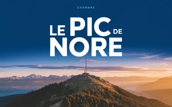 Le pic de Nore, sommet majestueux sous un ciel bleu, dominé par une antenne. Paysage montagneux au coucher du soleil.